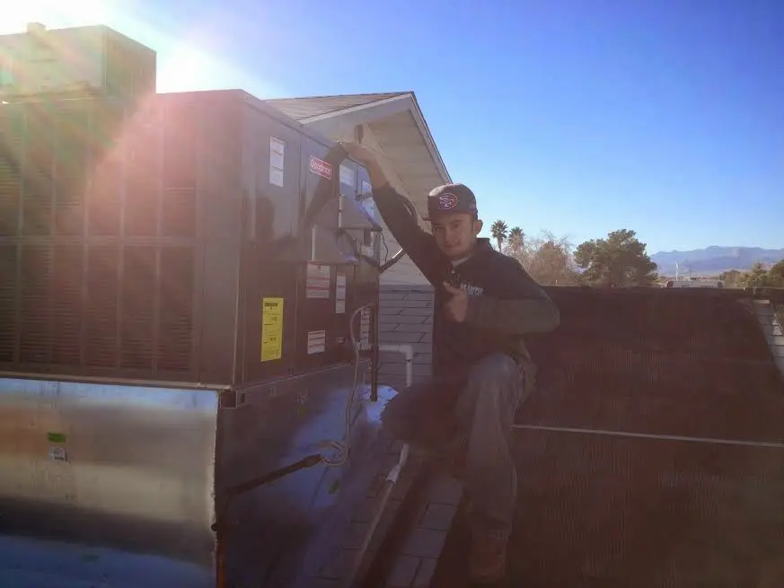 HVAC technician performing AC Tune-Up on a rooftop unit in Sandusky